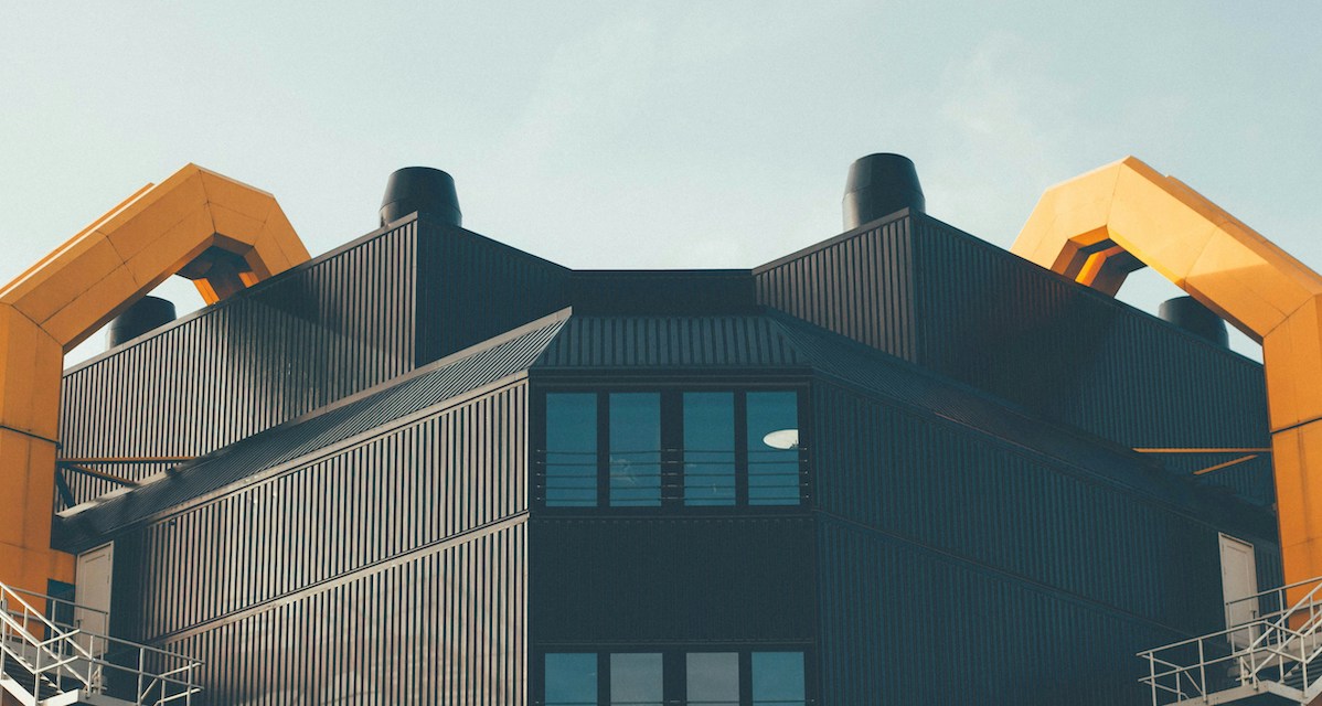 Ein brutalistisches Gebäude mit einer schwarzen und orangenen Metallverkleidung.